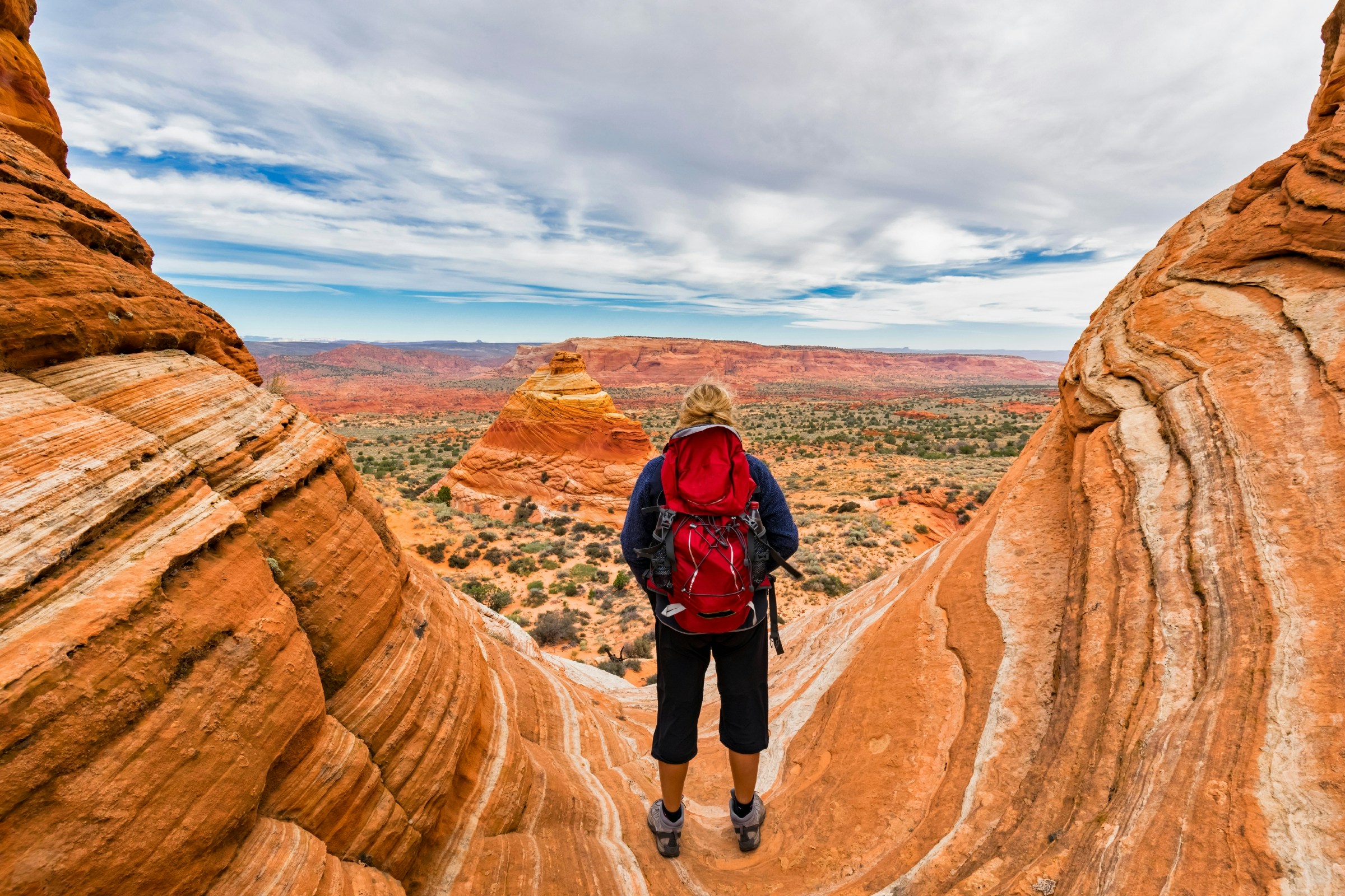 A tourist looking out over red stone pyramids and buttes in Arizona, USA