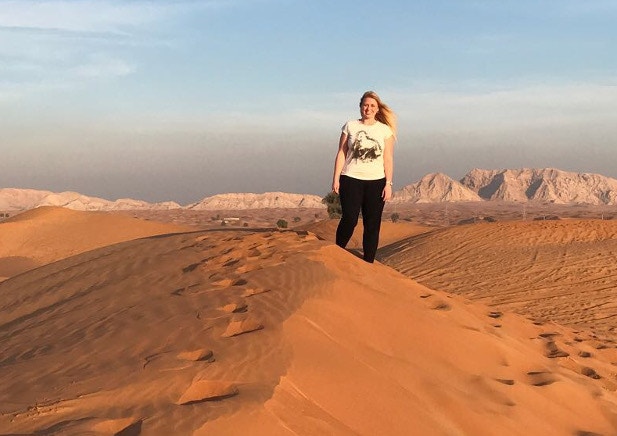 Kat stood on a sand dune with an impressive desert view stretching into the distance