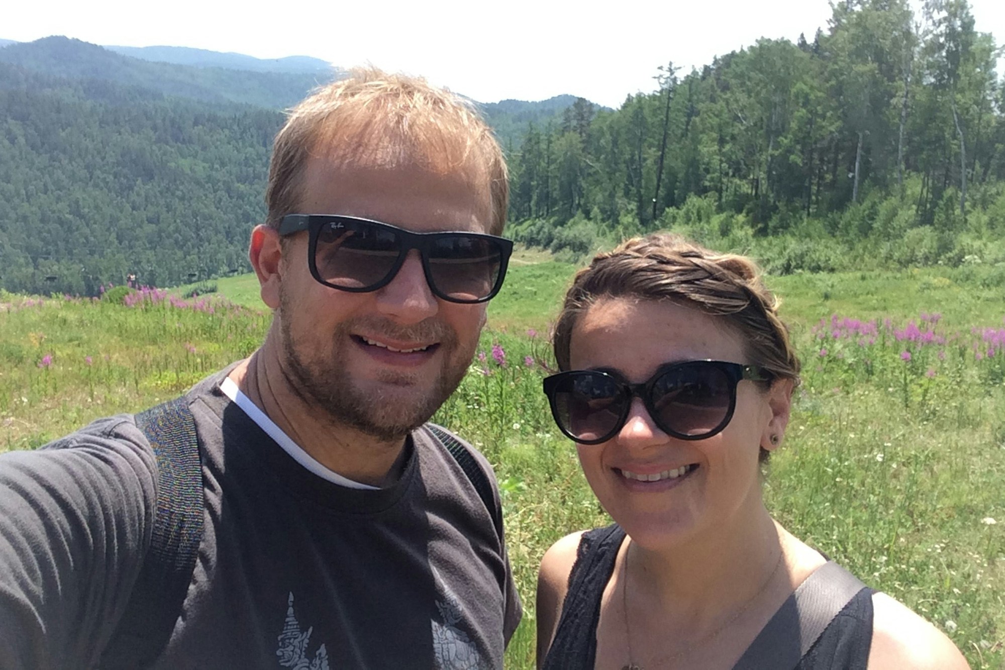 Trisha and her brother taking a selfie in front of a rural vista