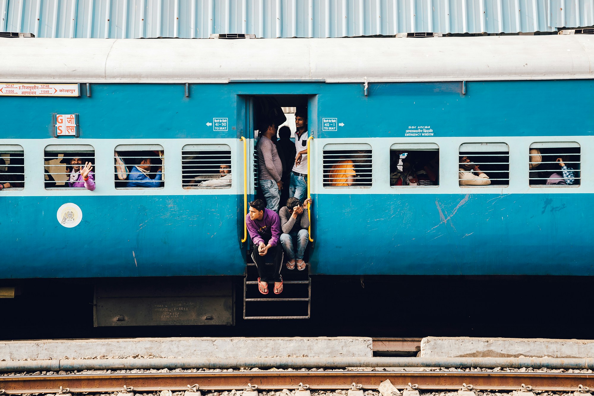 Passengers in the doorway of an Indian train