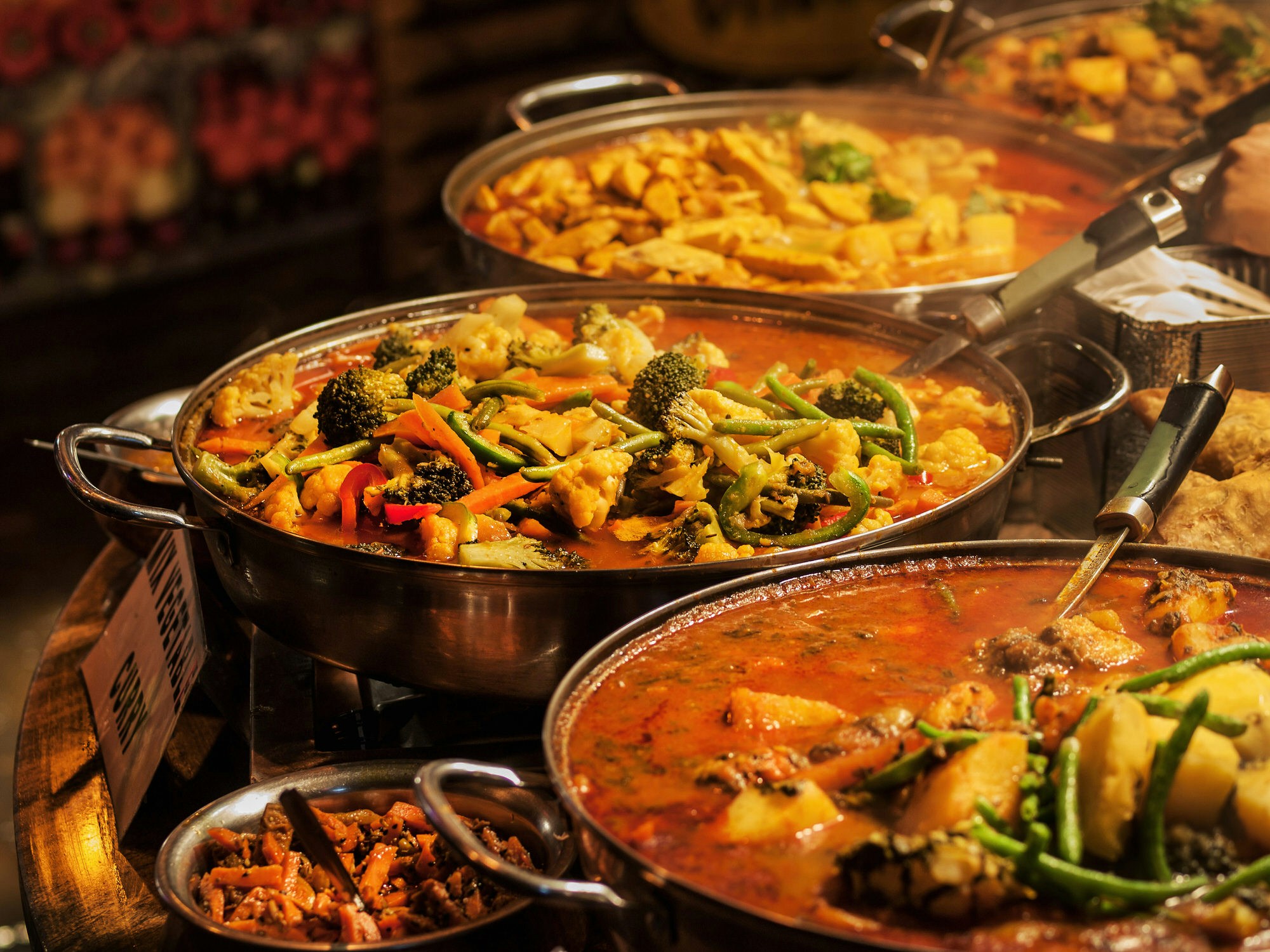 A selection of vegetable curries at an Indian takeaway in a London market
