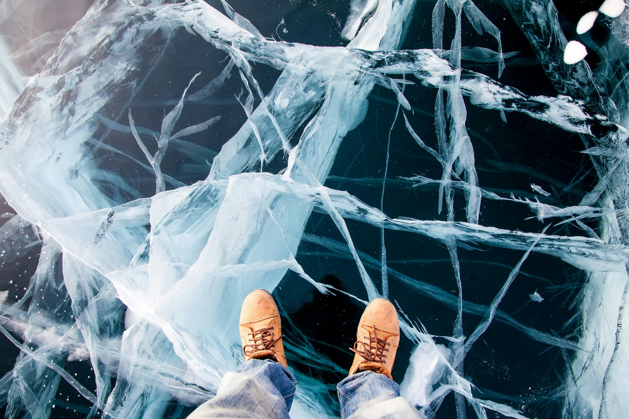 Man feet in boots on the Baikal ice